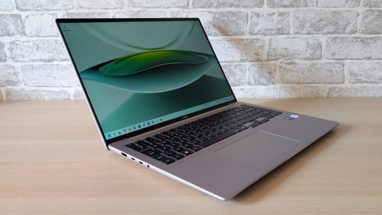 The Honor MagicBook 16 laptop on a wooden table with its lid open