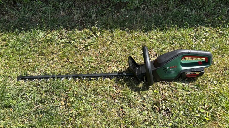 Bosch AdvancedHedgeCut 36V - wide shot of trimmer laid on grass